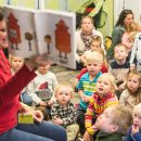 A librarian reads a robot storytime to a crowd of excited children