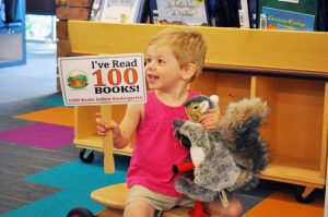 Image of child holding up a sign that says they have read 100 books