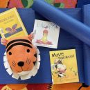 Yoga mats and children's books displayed on a floor mat.