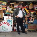 Joel Haertling standing in front of a large amount of items he's purchased from garage sales.