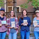4 members of a book circle holding copies of the 2021 One Book One Boulder book
