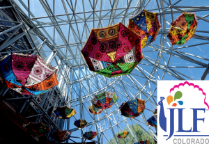 Image of colorful umbrellas hang upside down in the glass conoid of Main Library, with the JLF Colorado logo in the bottom right corner.