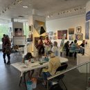 Community members gather in the gallery to look at art and activities.