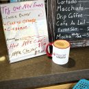 a coffee mug next to a sign displaying the cafe's specials